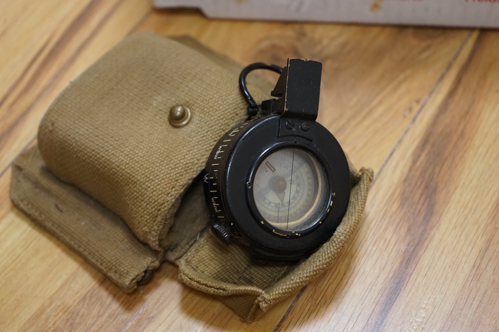 A Sykes-Fairburn Fighting Knife by Wilkinson sword in its leather scabbard, together with a 1942 Mk.III military compass by T.G.Co.Ltd. in a webbing pouch dated 1940, together with another compass, a telescope in a leath